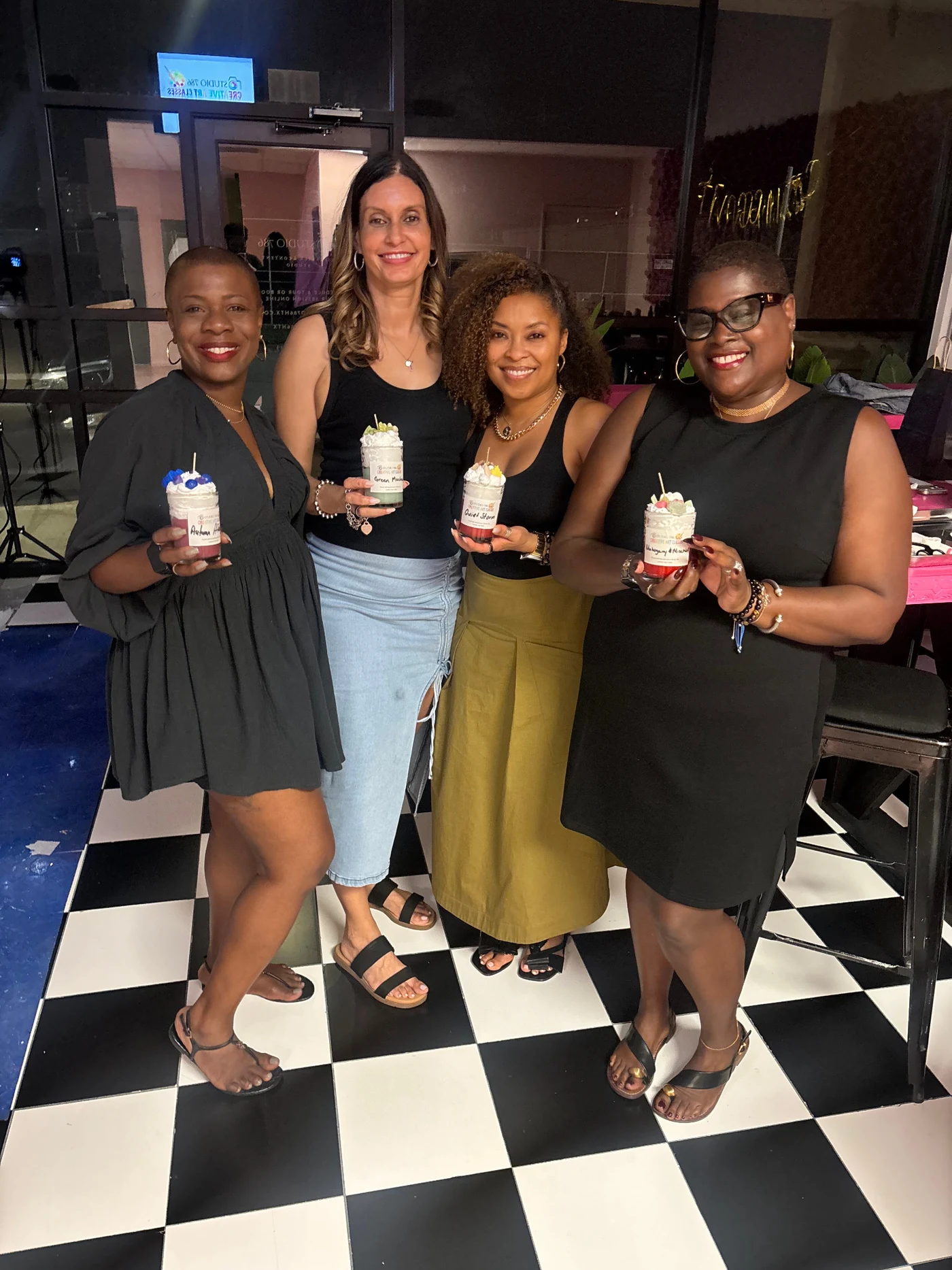 Four smiling Studio 786 guests holding their handmade dessert candles