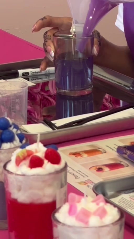 Dessert candles and hands piping purple wax into a clear vessel at Studio 786