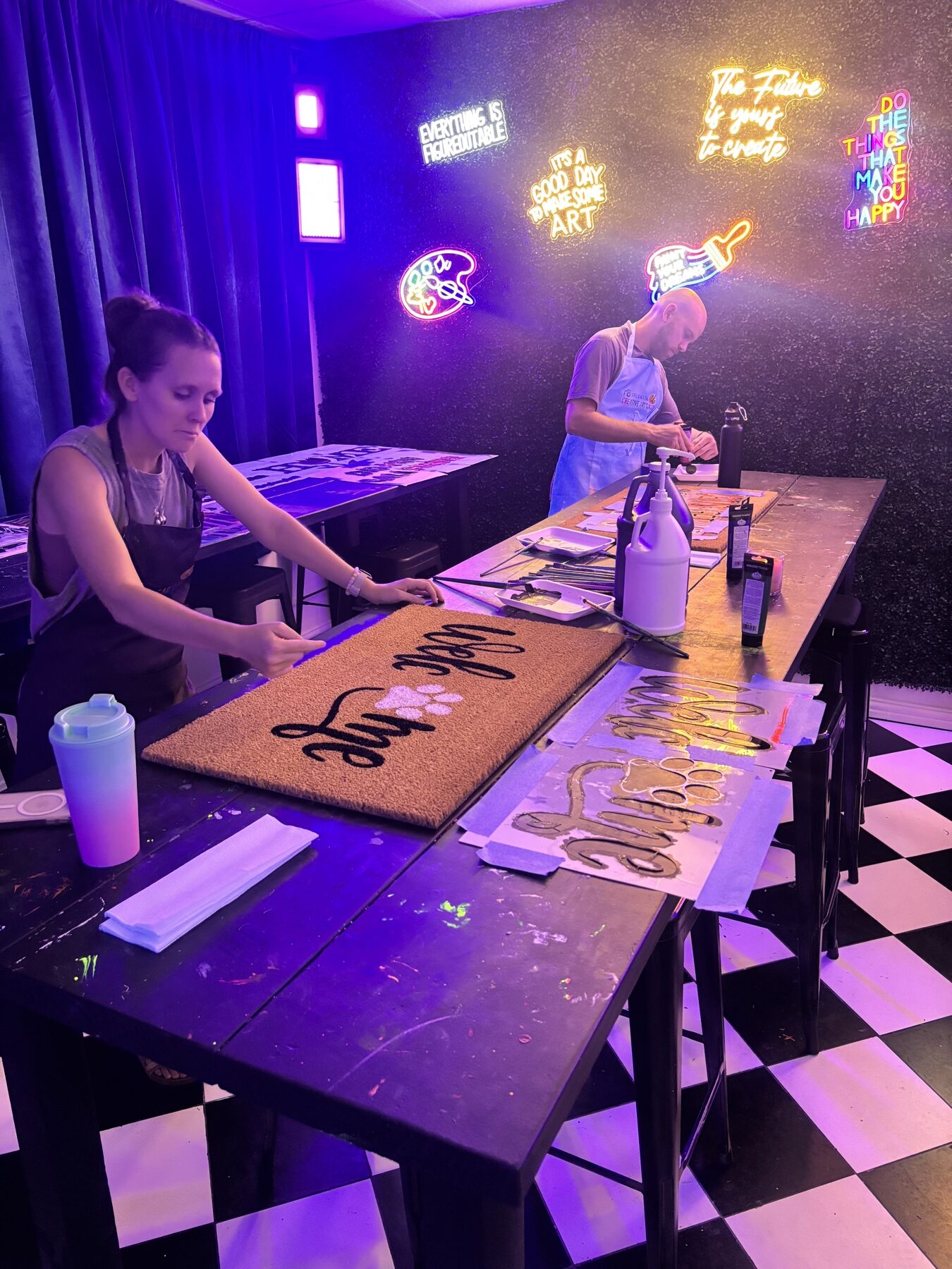 Guests painting custom doormats inside the LED art studio at Studio 786 Houston