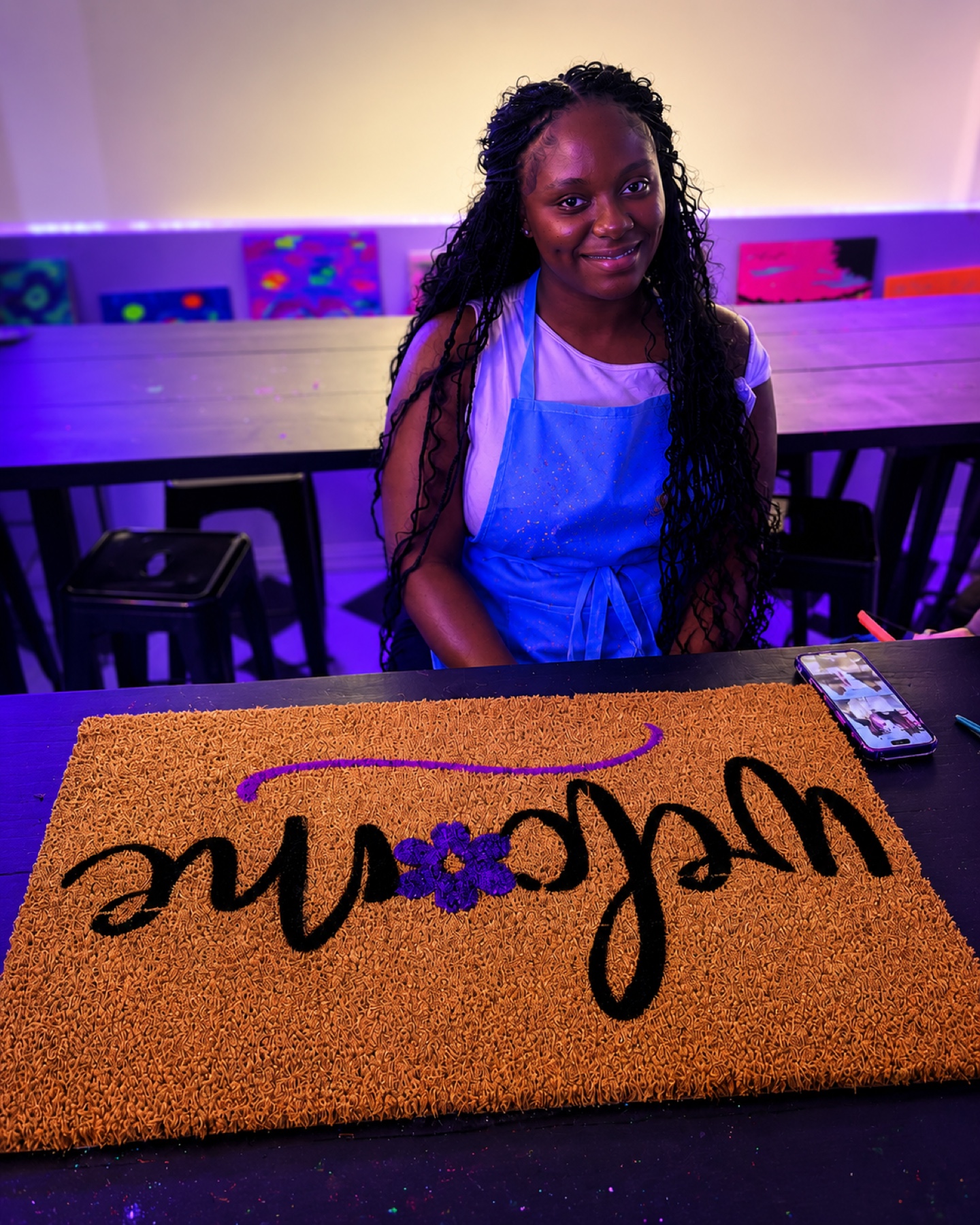 Guest painting a personalized welcome doormat at Studio 786 in Houston